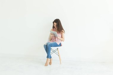 insanlar, teknoloji ve eğitim kavramı - genç öğrenci kadın bir sandalyede oturuyor ve kopya alanı beyaz zemin üzerine tablet kullanma