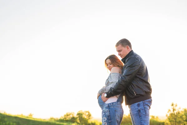 Concetto di famiglia, gravidanza e persone - Donna incinta con marito in natura — Foto Stock