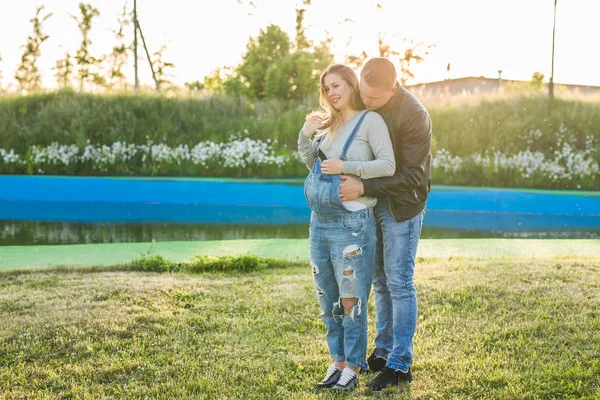 Amore, gravidanza e concetto di famiglia - Uomo che abbraccia la moglie incinta — Foto Stock