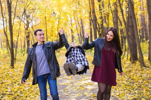 İnsanlar, Aile ve eğlence kavramı - Anne, baba ve küçük kız içinde sonbahar park eğlenmek — Stok fotoğraf