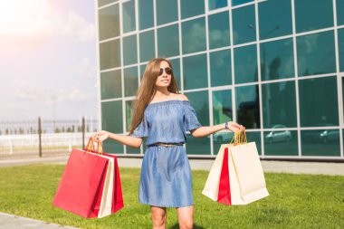 Satınalma, satış ve insanlar kavramı - alışveriş torbaları ile mutlu genç gülümseyen kadın