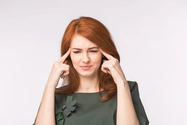 Femme rousse stressée touchant les tempes et réfléchissant dur sur fond blanc. Concept de stress ou maux de tête . — Photo