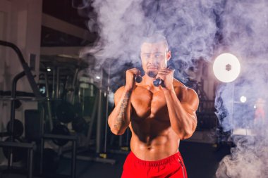 Boks egzersizleri yapıyorsun, tam isabet dumbbells ile güçlü bir adam. Sportif kaslı erkek fotoğrafı. Güç ve motivasyon