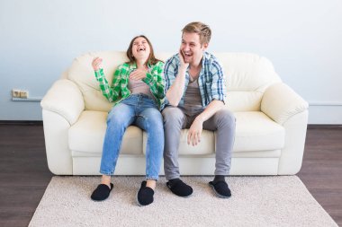 eğlenceli olan genç bir çift kanepede gülüyor