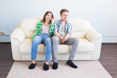 eğlenceli olan genç bir çift kanepede gülüyor