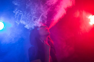 Genç kadın sigara vape veya e-sigara neon ışık