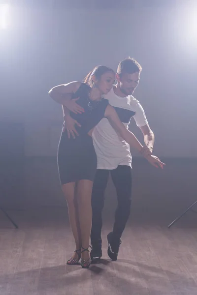 Pareja joven bailando baile latino Bachata, merengue, salsa. Dos poses de elegancia en clase de baile — Foto de Stock