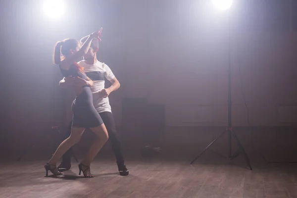 Pareja joven bailando social danse kizomba o bachata o semba o taraxia en clase de baile fondo — Foto de Stock