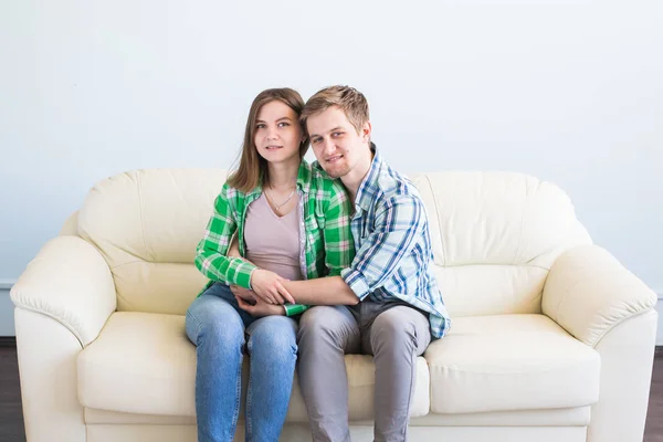Портрет молодой любящей пары, отдыхающей дома на диване и обнимающейся . — стоковое фото