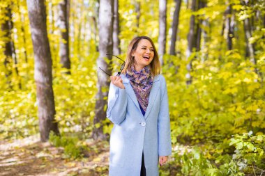 Doğa, sezon ve insanlar kavramı - genç kadın sonbahar parkta gülüyor