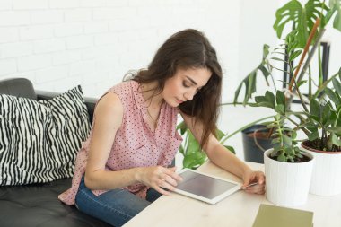 Teknolojileri, iletişim, kadın deri koltukta oturan ve dijital tablet kullanarak kavramı - genç insanlar