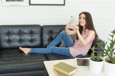 Teknoloji, fotoğraf ve insanlar kavramı - karanlık kanepede yatan bir selfies alarak güzel bir kadın portresi