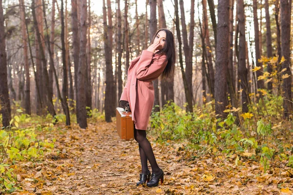 Mulher bonita no parque de outono posando com mala — Fotografia de Stock