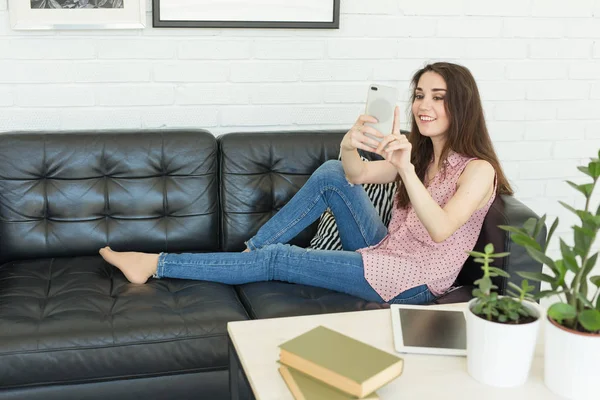 Teknoloji, fotoğraf ve insanlar kavramı - karanlık kanepede yatan bir selfies alarak güzel bir kadın portresi