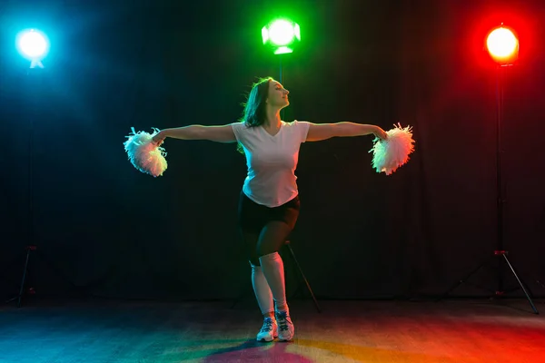 Retrato de comprimento total de cheerleader dançando com pom-poms — Fotografia de Stock