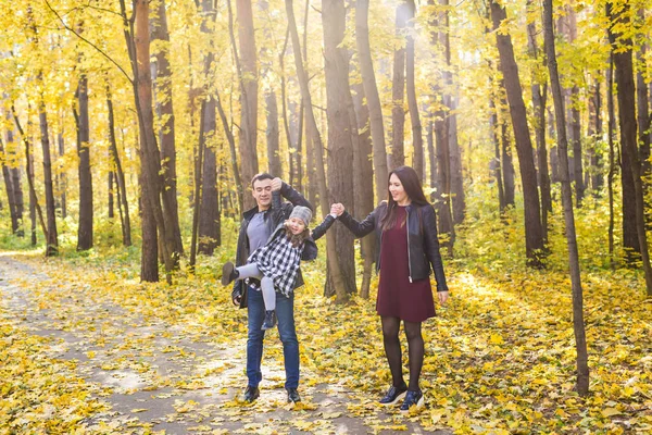 家族とレジャー コンセプト 幸せな父と母は自分の娘と秋の公園で楽しい時を過す — ストック写真