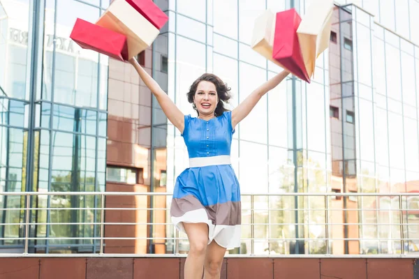 Konsum, Verkauf und Menschen-Konzept - glückliche junge Frau hat Spaß mit Einkaufstüten auf der Straße — Stockfoto