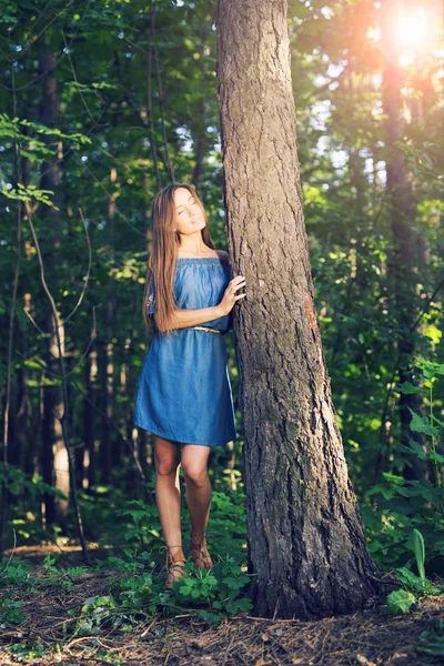 Natuur, zomer en mensen concept - jonge vrouw poseren in het groene woud — Stockfoto