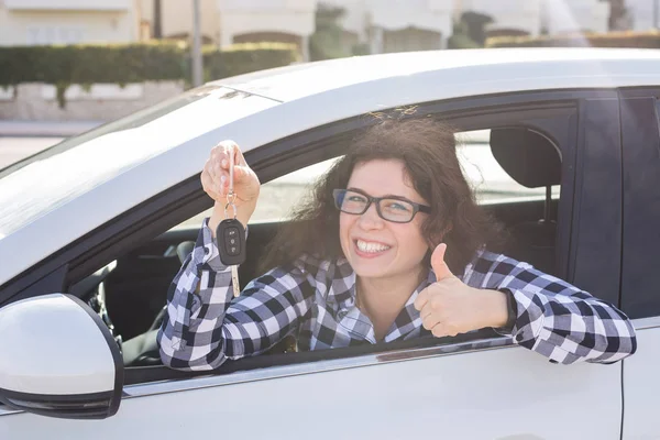 Glückliche Frau zeigt Daumen hoch und fährt ein neues Auto. positiver Gesichtsausdruck — Stockfoto