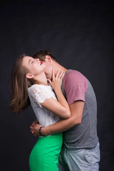 Любовники целуют друг друга на черном фоне — стоковое фото