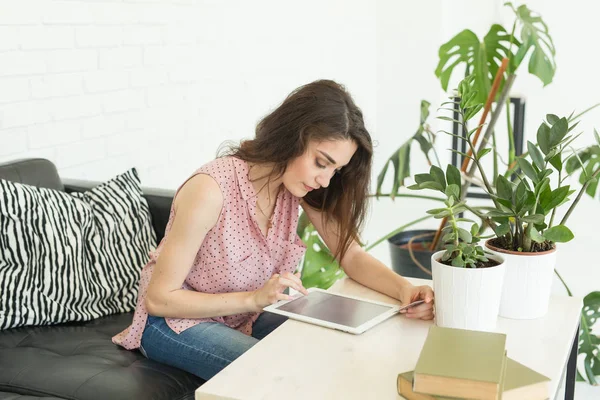 Tecnologia e concetto di persone - bella ragazza seduta al tavolo bianco con tablet — Foto Stock