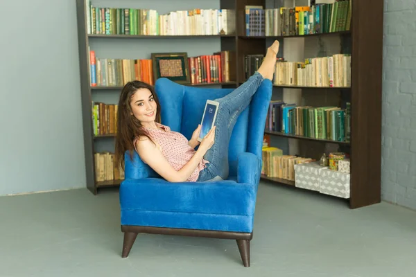 Persone, istruzione e concetto di interni - studio delle studentesse nella biblioteca scolastica sulla sedia — Foto Stock
