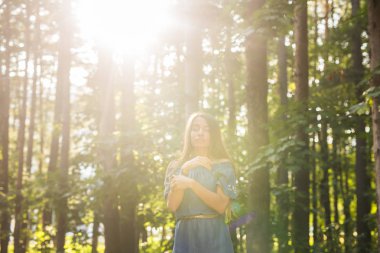 Doğa, yaz ve insanlar kavramı - genç kadın yeşil ormanda poz