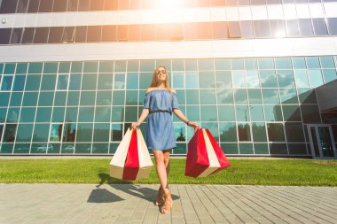 Satınalma, satış ve insanlar kavramı - alışveriş torbaları ile mutlu genç gülümseyen kadın