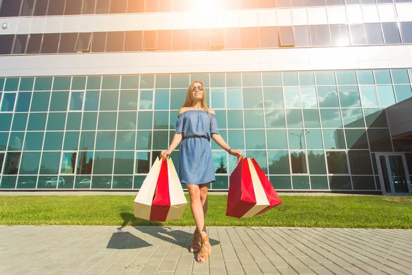 Satınalma, satış ve insanlar kavramı - alışveriş torbaları ile mutlu genç gülümseyen kadın