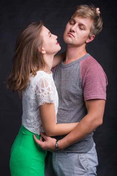 Vackert ungt par kramas och kyssas isolerad på svart bakgrund. — Stockfoto