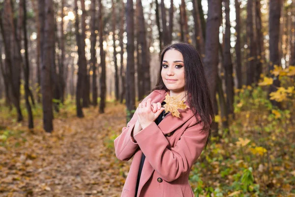 Mensen, seizoen en stijl concept - mooie jonge vrouw die lacht in herfst park — Stockfoto