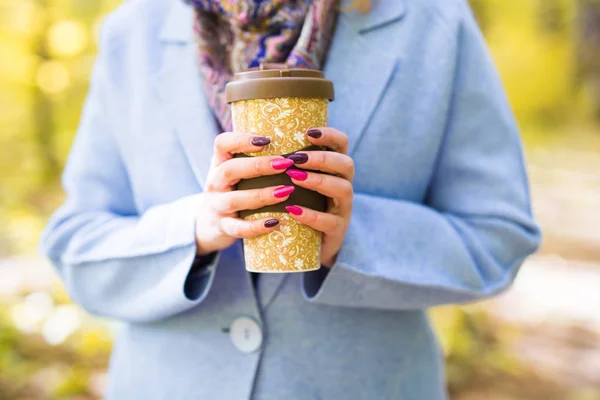 Close up de mulher segurando uma xícara de café takeaway na rua de outono — Fotografia de Stock