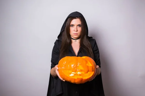 Jovem mulher no traje de bruxa Halloween no estúdio com abóbora amarela no fundo branco com espaço de cópia — Fotografia de Stock