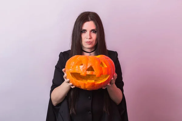 Jovem mulher em Halloween traje de bruxa no estúdio com abóbora amarela . — Fotografia de Stock