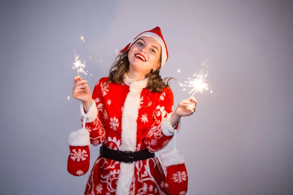 Weihnachten, Feiertage und Menschen-Konzept - Frau im Weihnachtsanzug mit Lichtern und Funkeln lacht. — Stockfoto