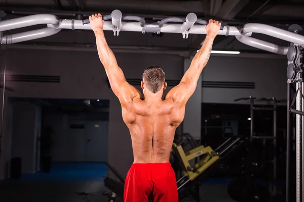 Stilig muskulös Man med perfekt kropp gör dra Ups i gym — Stockfoto