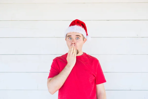 Mensen, emoties en Kerstmis concept - verraste de jonge mens in santa claus kostuum op witte achtergrond — Stockfoto