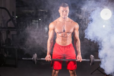 Spor salonunda ağırlık kas genç adam