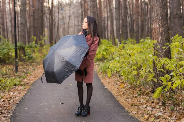 Season, fall and people concept - Portrait of beautiful smiling woman in pink coat with black umbrella — Stock Photo, Image