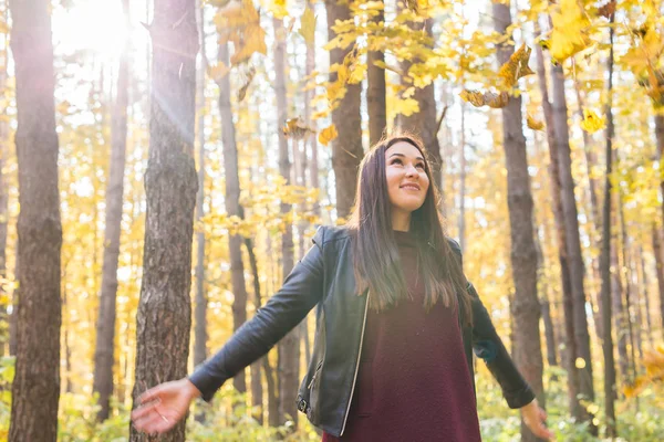 Herfst, natuur en leuk concept - mooie jongedame in lederen jas gooien boeket van bladeren — Stockfoto