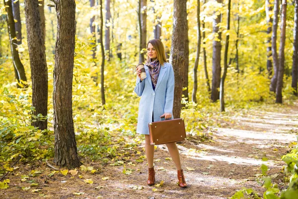 Outono, natureza e conceito de pessoas - Jovem mulher bonita de casaco azul segurando uma xícara de café — Fotografia de Stock
