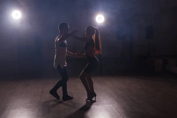 Giovane coppia che balla social danse kizomba o bachata o semba o taraxia in fondo alla classe di danza — Foto Stock
