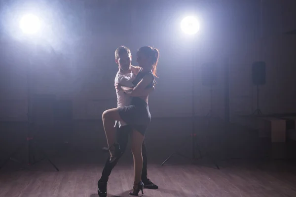 Casal jovem dançando danse social kizomba ou bachata ou semba ou taraxia em fundo de aula de dança — Fotografia de Stock