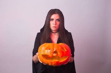 Halloween cadı bir turuncu kabak Jack o fener duman ile tutarak