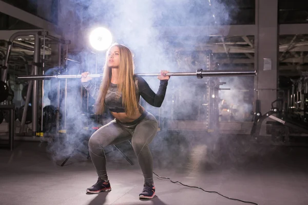 Güzel kadın bir spor salonunda barbell ile çalışma dışarı — Stok fotoğraf