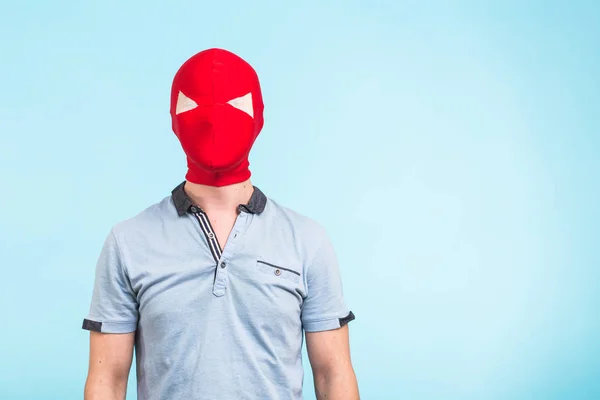 Homem usando máscara vermelha no fundo azul com espaço de cópia. Conceito anônimo de mascaramento social. Halloween. — Fotografia de Stock