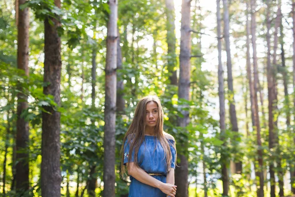 Natuur, zomer en mensen concept - portret van romantische jonge vrouw in het bos — Stockfoto