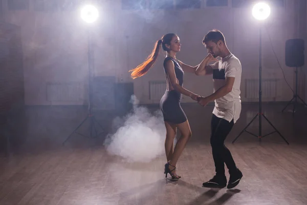 Молодая пара танцует социальный данс кизомба или бачата или семба или тараксия в танцевальном классе — стоковое фото