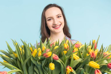 Büyük bir demet lale mavi zemin üzerine beyaz genç kadın