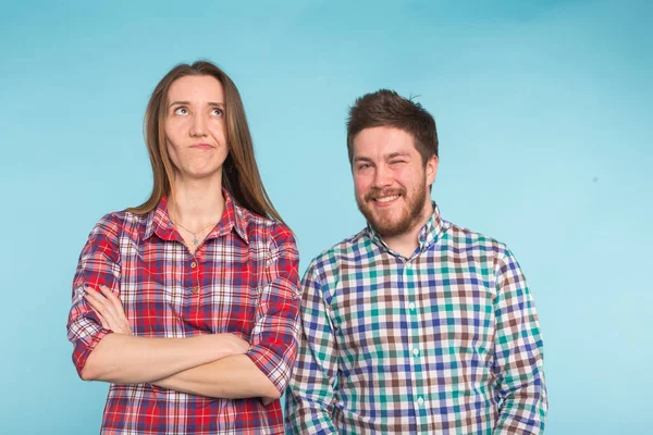 Engraçado jovem casal rindo e brincando juntos no fundo azul . — Fotografia de Stock